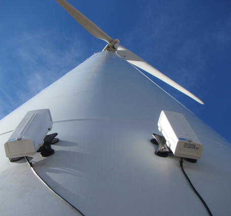 Bat, bird, and insect activity can be monitored with pairs of thermal-imaging cameras mounted on the wind turbines (a), and automatically recorded to a computer inside the base of the turbine (b). (From Cryan et al., Animals 2022, 12(1)